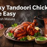 Smoky tandoori chicken on white plate with lemon wedges and onion slices garnish