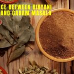 Difference between Biryani Masala and Garam Masala with a bowl of ground spice, whole spices including bay leaves, cloves, cardamom, cumin, red chilies, and Sparsh Masala branding on a wooden background.